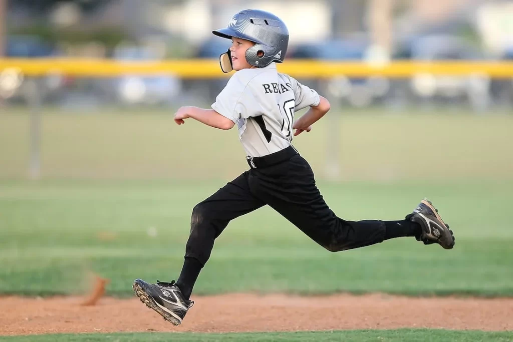 Child baseball player running.