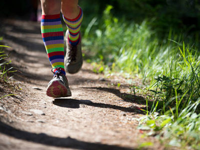 Person jogging on a dirt trail.