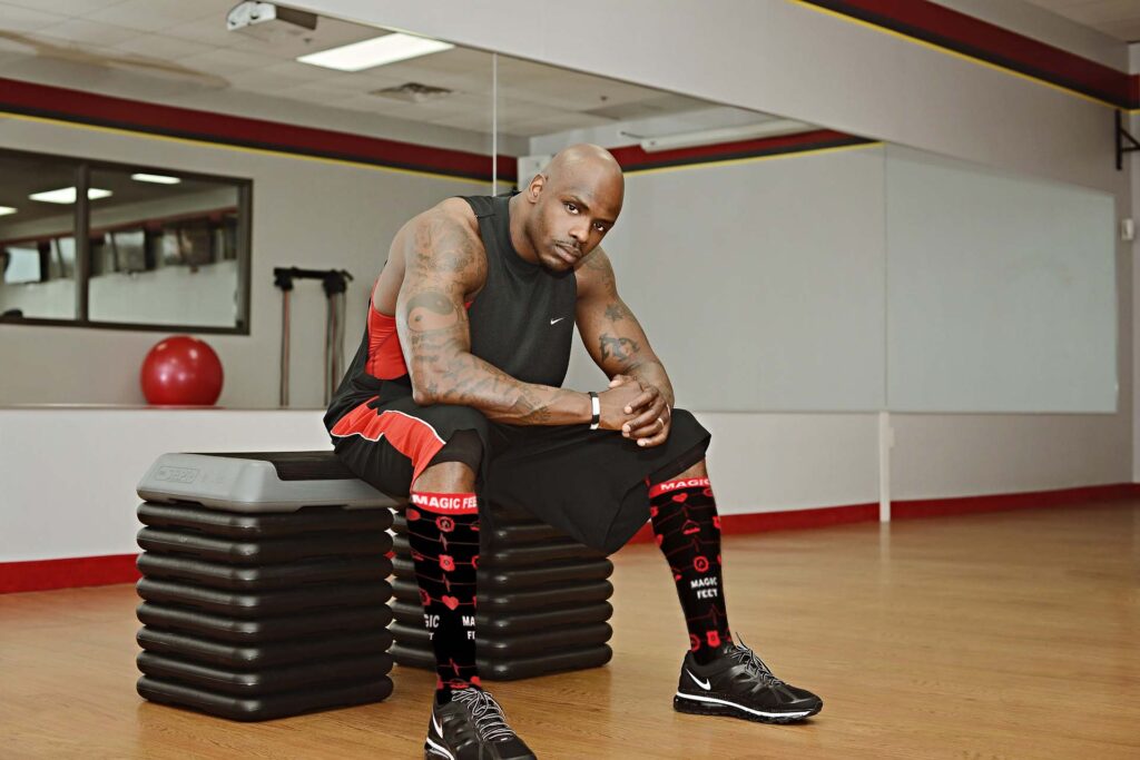 Fit man sitting on weights with Magic Feet compression socks