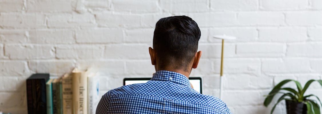 Sitting man looking at his laptop.