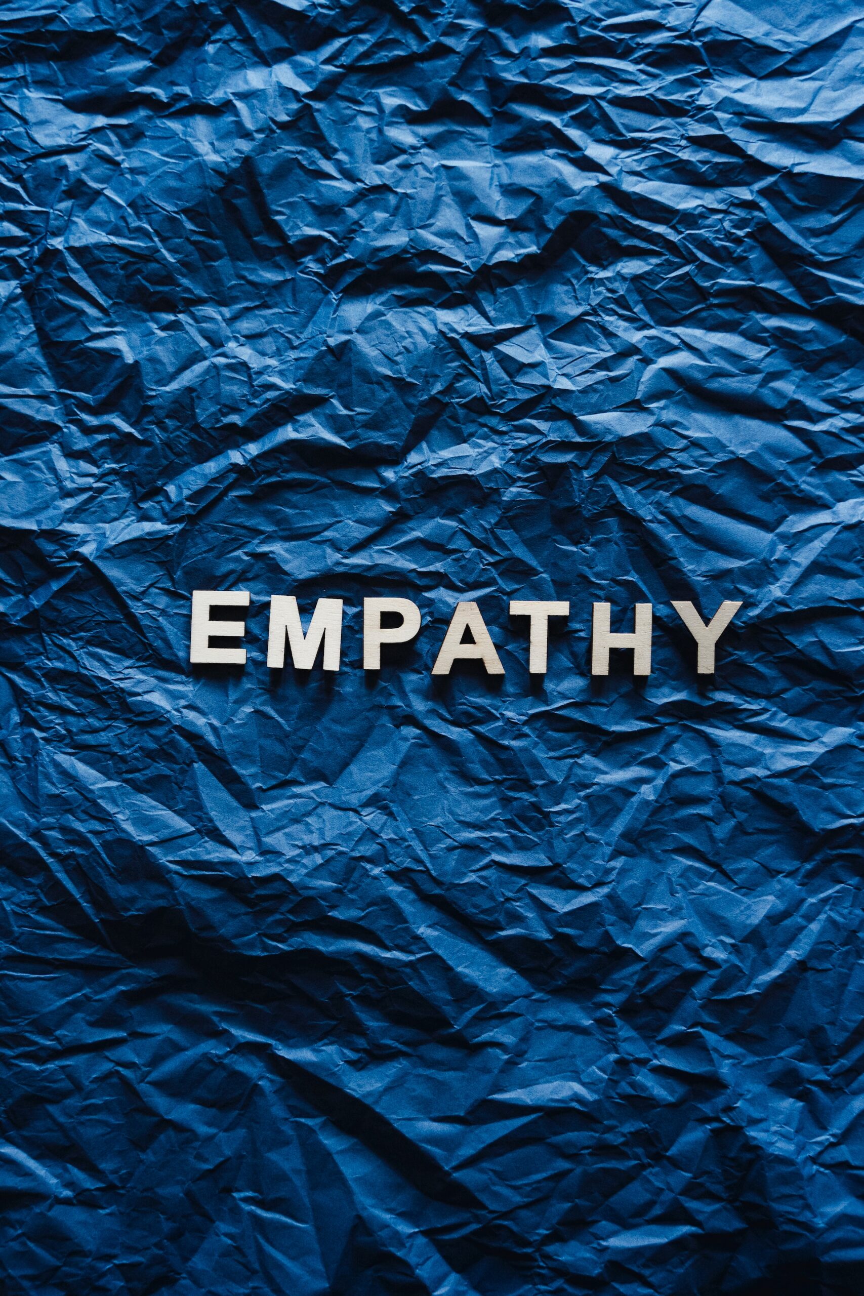 The word empathy spelt out on a blue wrinkled sheet.