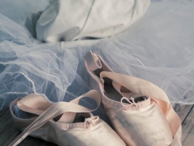 Pointe shoes and a leotard with a tutu behind the pointe shoes.