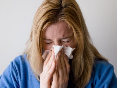 A women blowing her nose.