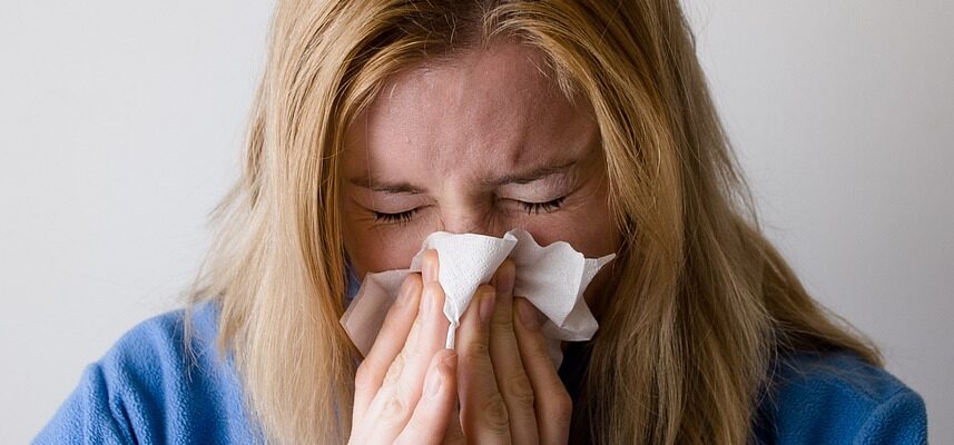 A women blowing her nose.