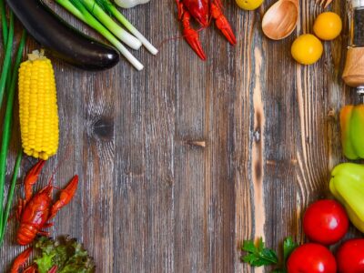 An assortment of vegetables and shellfish on a wooden table