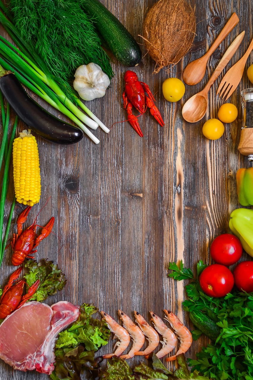 An assortment of vegetables and shellfish on a wooden table