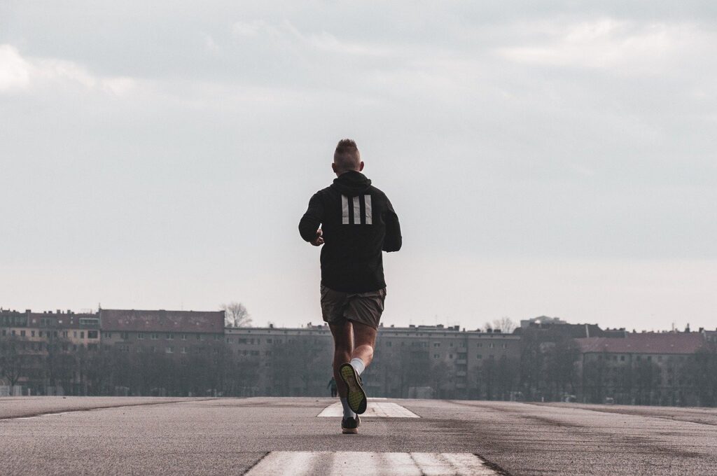 Man running down an open road. 