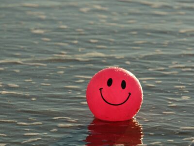 A ball with a happy face floating in water.