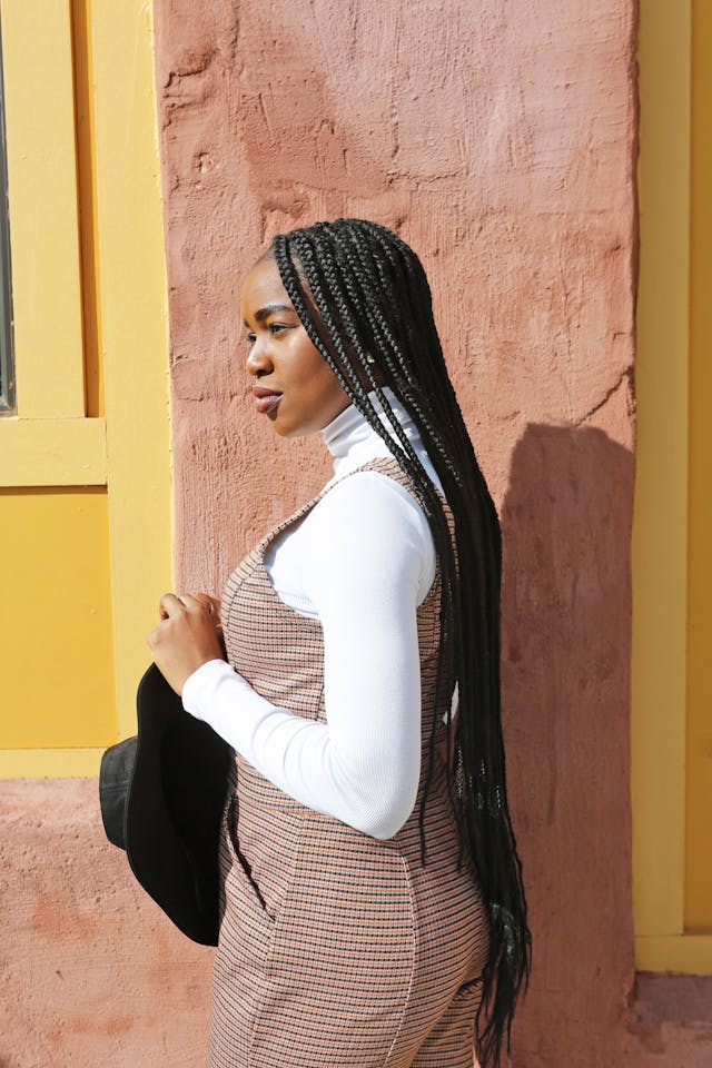 Image of black woman with long black colored knotless box braids.