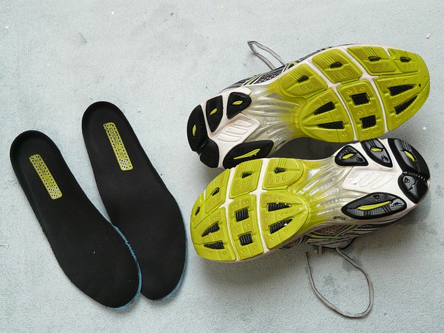 Neon green sneakers next to two pairs of insoles, presumably for a person with flat feet.