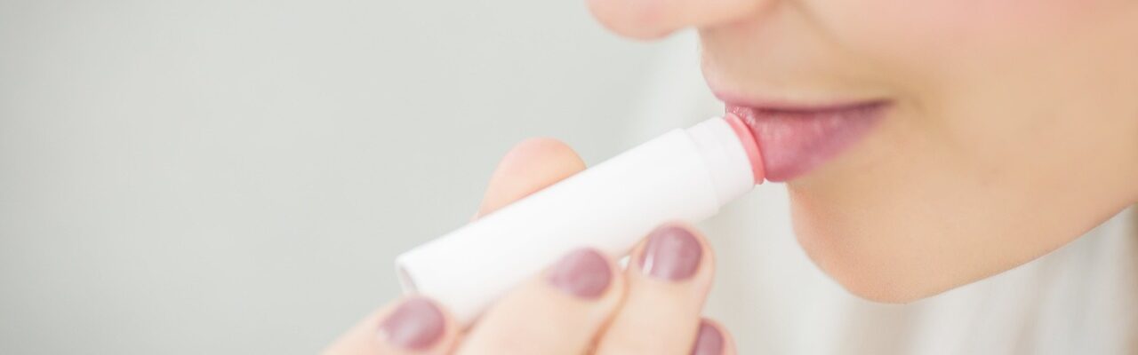 A person putting on chapstick.