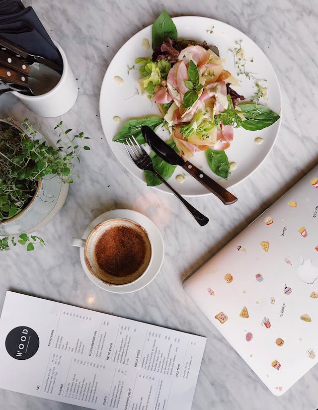 Salad and coffee on restaurant table for self care day.