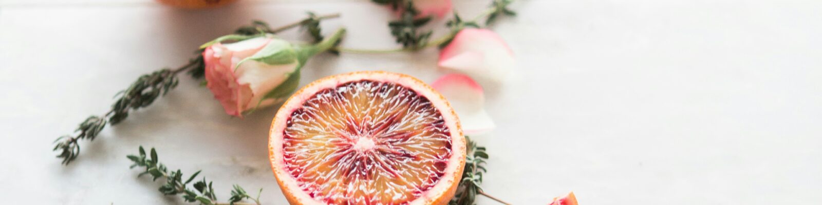 Citrus and dried flowers spread out on white counter