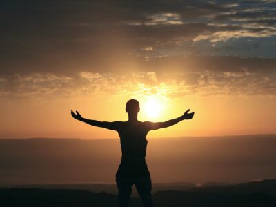 Woman in front of sunrise.