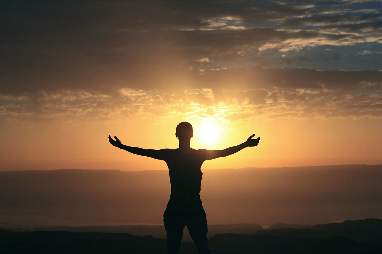 Woman in front of sunrise.