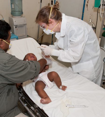 Masked doctor taking care of a baby